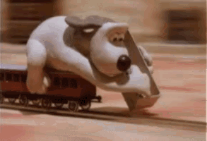 A GIF of Gromit laying tracks in front of a train.